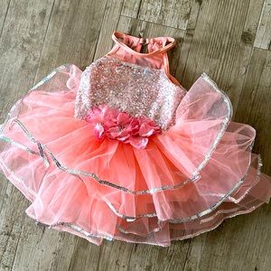 A dancer outfit in peach with sequins and a tutu. It is size XSC.